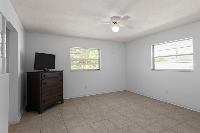 bedroom with ceiling fan, a textured ceiling, and baseboards