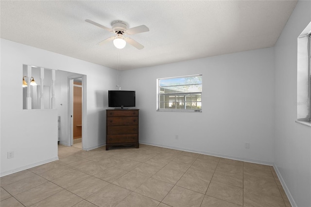 unfurnished bedroom featuring ceiling fan, a textured ceiling, and baseboards