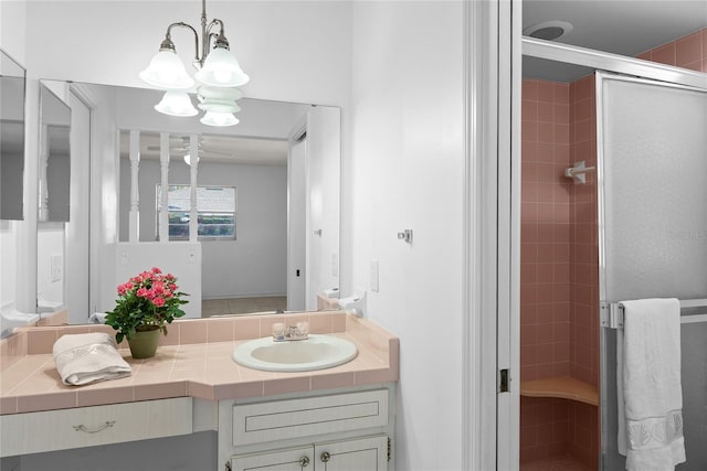 full bath with a stall shower, an inviting chandelier, and vanity