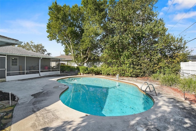 pool with a sunroom, fence, and a patio