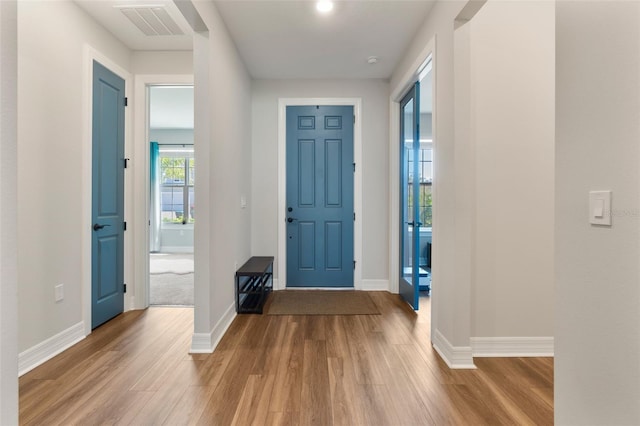 entryway with wood finished floors, visible vents, and baseboards