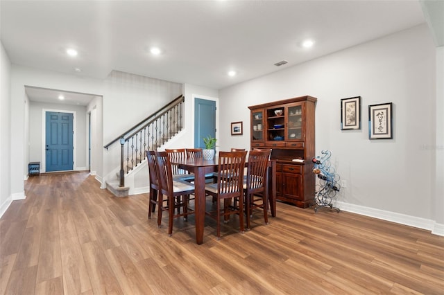 dining room with stairs, baseboards, light wood-style flooring, and recessed lighting