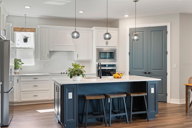 kitchen with stainless steel appliances, dark wood-style flooring, light countertops, and white cabinets