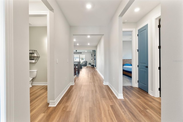 hallway featuring recessed lighting, light wood-style flooring, and baseboards