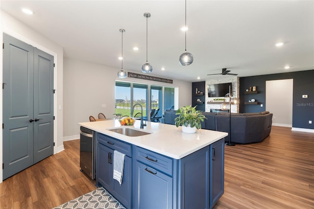 kitchen featuring light countertops, wood finished floors, a sink, and blue cabinets