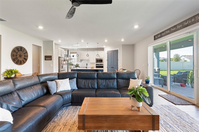 living room featuring a ceiling fan, recessed lighting, visible vents, and light wood-style floors