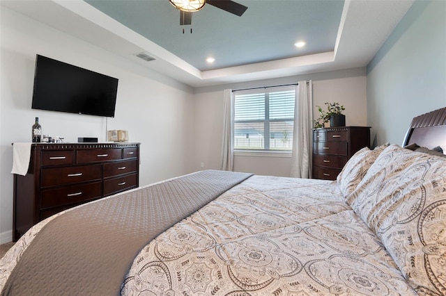 bedroom featuring a ceiling fan, a raised ceiling, visible vents, and recessed lighting