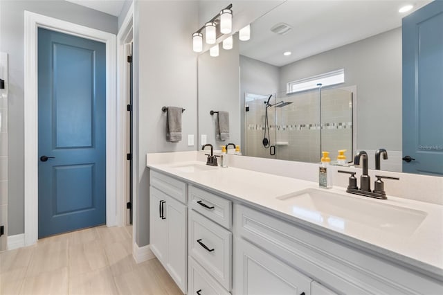 full bath with double vanity, a stall shower, visible vents, and a sink