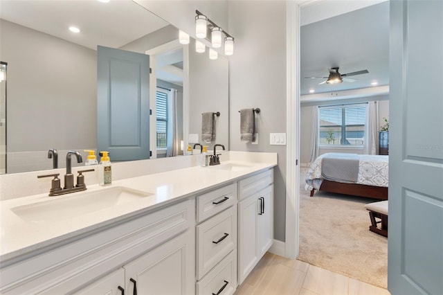 ensuite bathroom featuring connected bathroom, recessed lighting, a sink, and double vanity