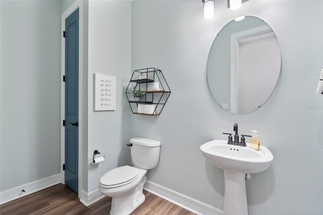 bathroom featuring toilet, baseboards, and wood finished floors