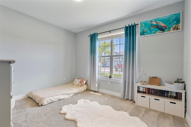 bedroom with baseboards and light colored carpet