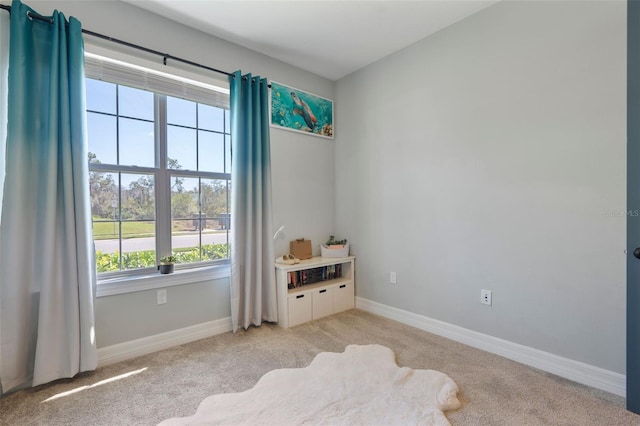 spare room with baseboards and light colored carpet