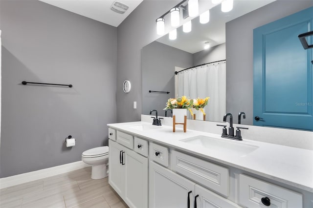 full bath with toilet, baseboards, visible vents, and a sink