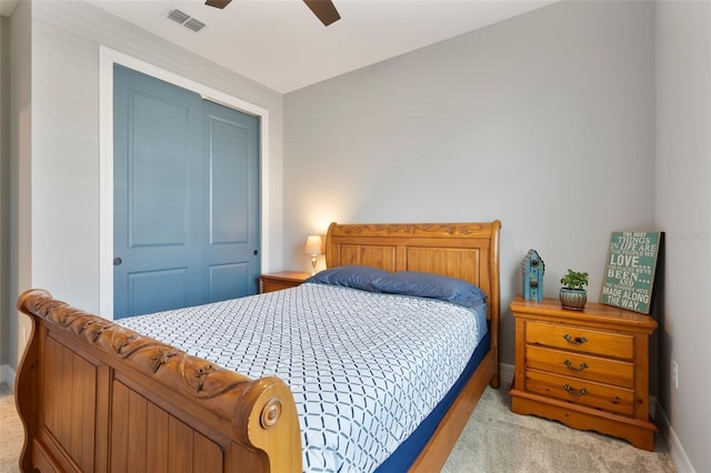 bedroom with light carpet, ceiling fan, visible vents, and baseboards