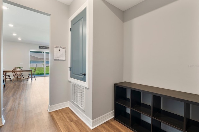 hall with recessed lighting, wood finished floors, visible vents, and baseboards