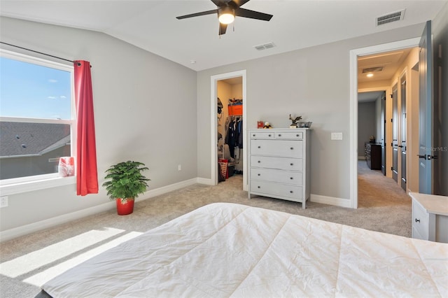 carpeted bedroom featuring lofted ceiling, visible vents, a spacious closet, and baseboards