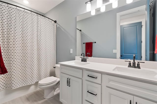 full bathroom featuring toilet, shower / bath combination with curtain, double vanity, and a sink