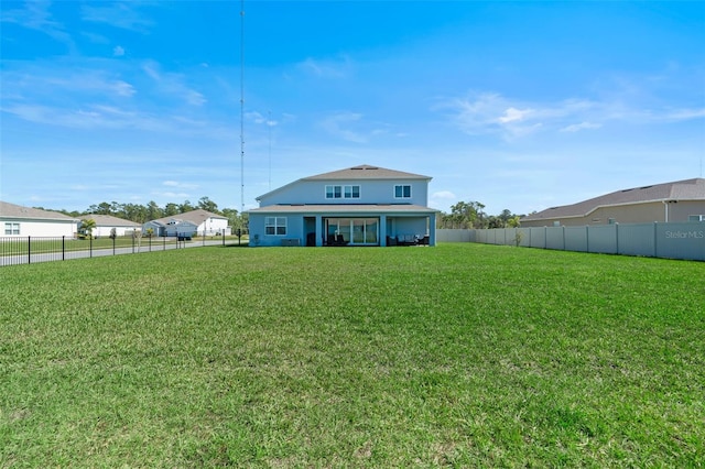 back of house featuring fence private yard and a lawn