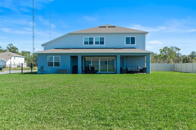 back of property with a shingled roof, a lawn, and fence