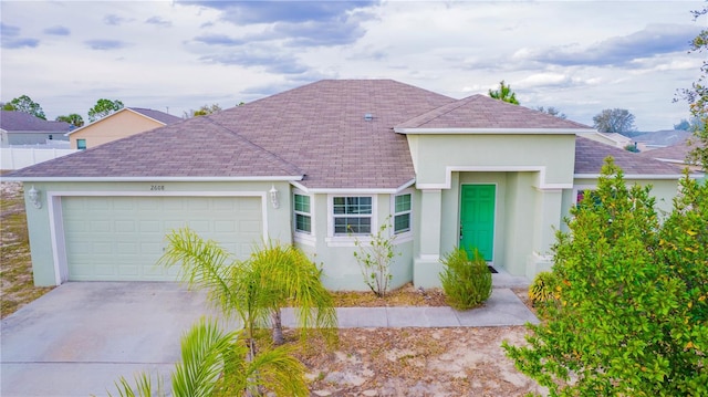 single story home featuring an attached garage, driveway, and stucco siding