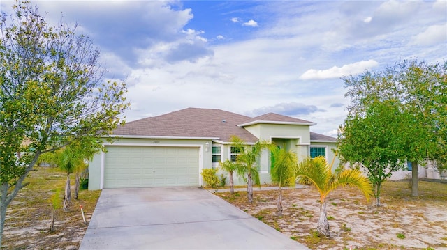 view of front of home with a garage, driveway, and stucco siding