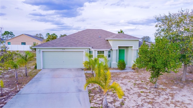 view of front of home featuring an attached garage, concrete driveway, and stucco siding