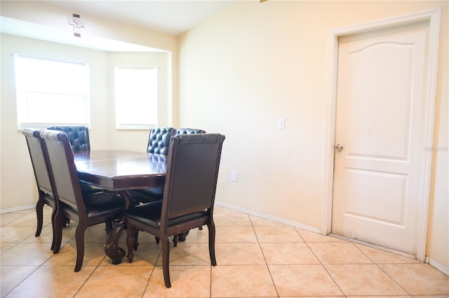 dining space with light tile patterned floors and baseboards