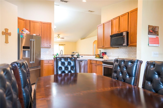 kitchen featuring a sink, a ceiling fan, light countertops, appliances with stainless steel finishes, and backsplash