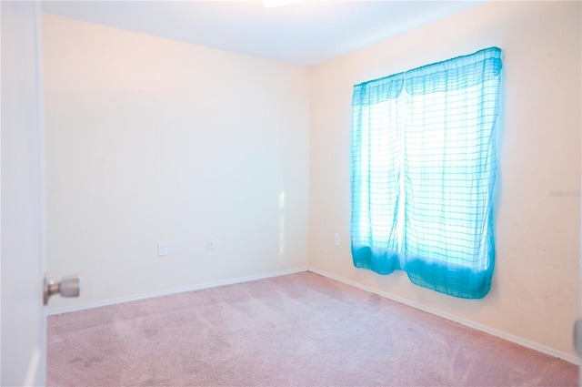 carpeted empty room with plenty of natural light and baseboards