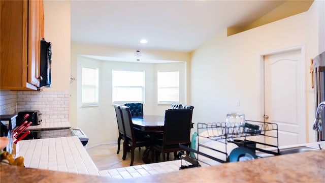 dining room with light tile patterned floors, recessed lighting, and baseboards