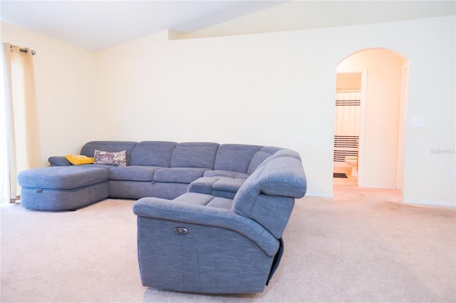 living room featuring arched walkways, baseboards, vaulted ceiling, and carpet