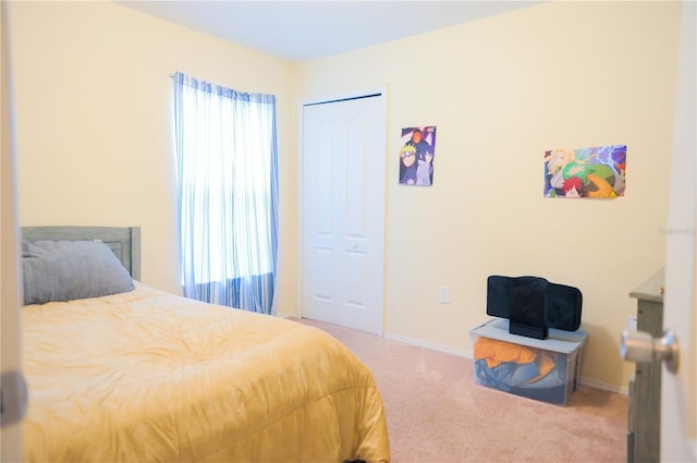 bedroom with carpet, baseboards, and a closet