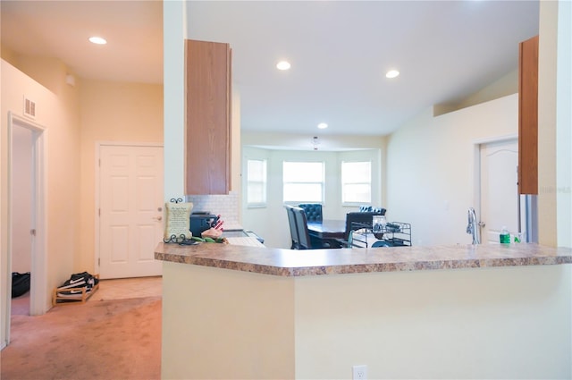 kitchen featuring recessed lighting, light colored carpet, backsplash, and a peninsula