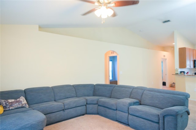 living room featuring vaulted ceiling, a ceiling fan, visible vents, and light colored carpet