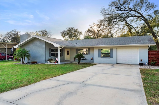 ranch-style home featuring driveway, a chimney, an attached garage, a front yard, and brick siding