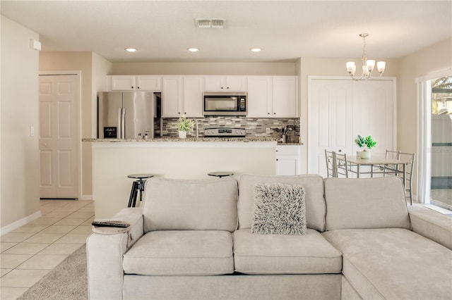 living room with light tile patterned floors, recessed lighting, visible vents, an inviting chandelier, and baseboards