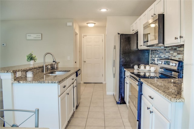 kitchen with light tile patterned floors, appliances with stainless steel finishes, a sink, and white cabinetry