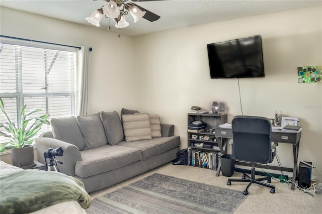 home office featuring carpet floors, a textured ceiling, and a ceiling fan