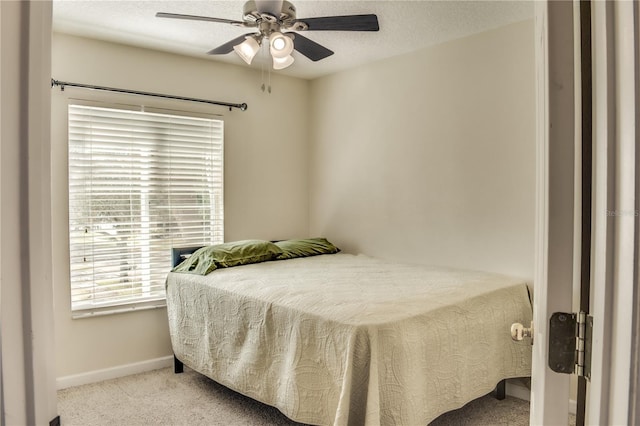 bedroom with a ceiling fan, carpet flooring, a textured ceiling, and baseboards