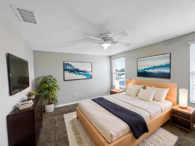 carpeted bedroom featuring baseboards, visible vents, and a ceiling fan