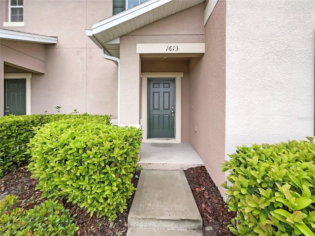 entrance to property featuring stucco siding