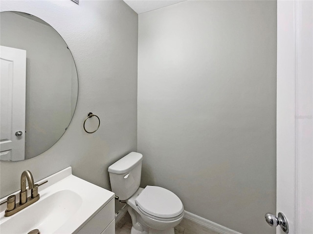 half bath featuring toilet, baseboards, and vanity