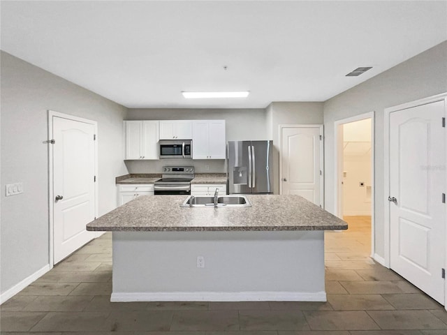 kitchen with a center island with sink, stainless steel appliances, visible vents, white cabinets, and a sink