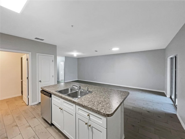 kitchen with visible vents, open floor plan, a sink, white cabinetry, and stainless steel dishwasher