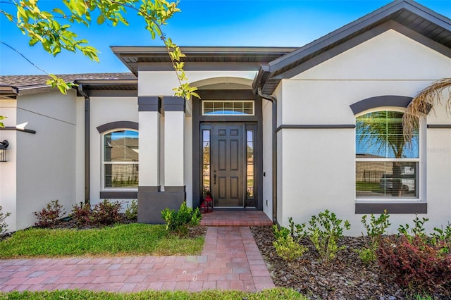 view of exterior entry with stucco siding