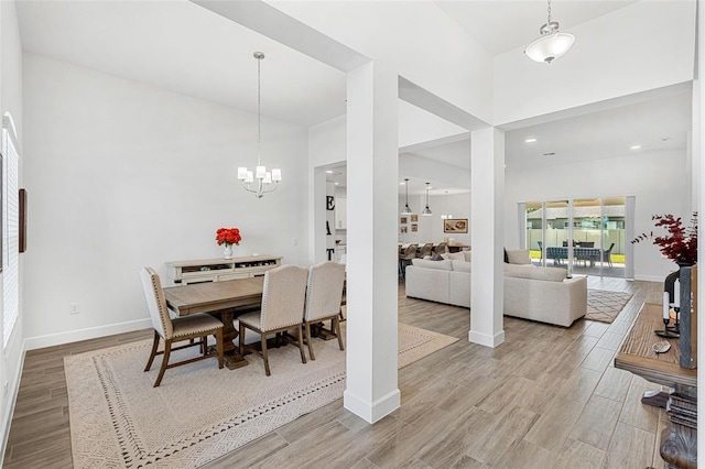 dining area with baseboards, wood finished floors, and a high ceiling