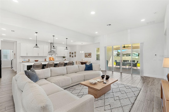 living room featuring recessed lighting, wood tiled floor, visible vents, and baseboards