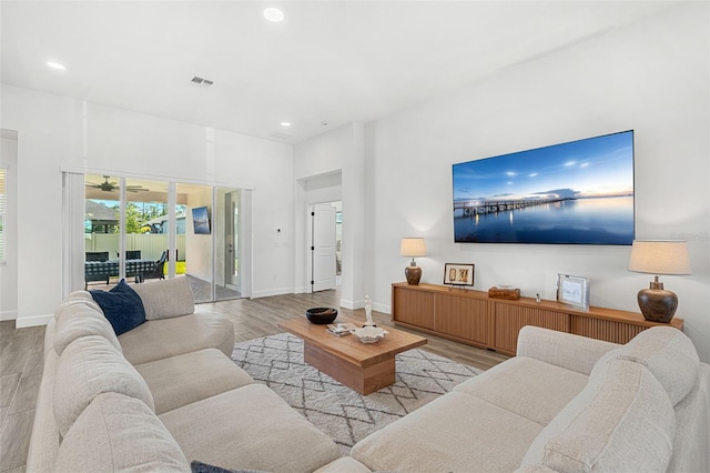 living area with baseboards, wood finished floors, visible vents, and recessed lighting