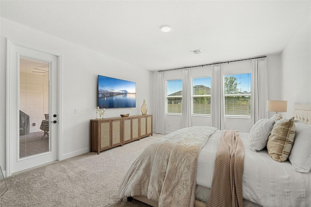 carpeted bedroom featuring visible vents, baseboards, and access to exterior