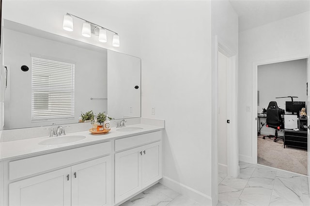 full bathroom with marble finish floor, baseboards, a sink, and double vanity